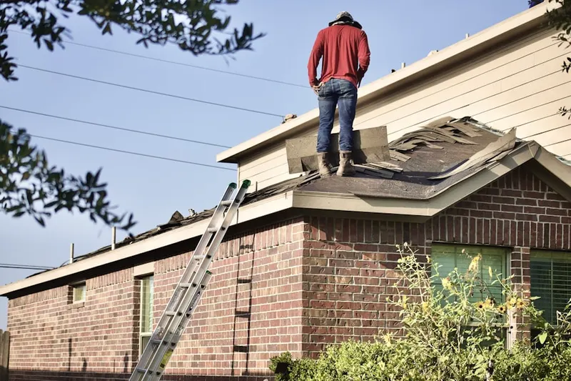 Professional roofer working on a residential roof in Frederick